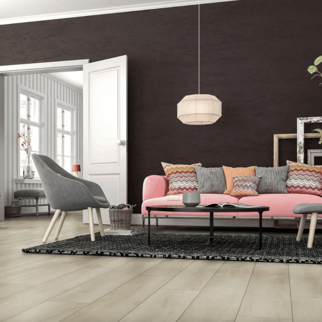 Moderni olohuone, jossa vaaleanpunainen sohva, musta seinä ja vaalea puukuvioinen laminaattilattia.